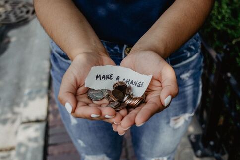Girl holding change. Photo by Kat Yukawa via Unsplash.